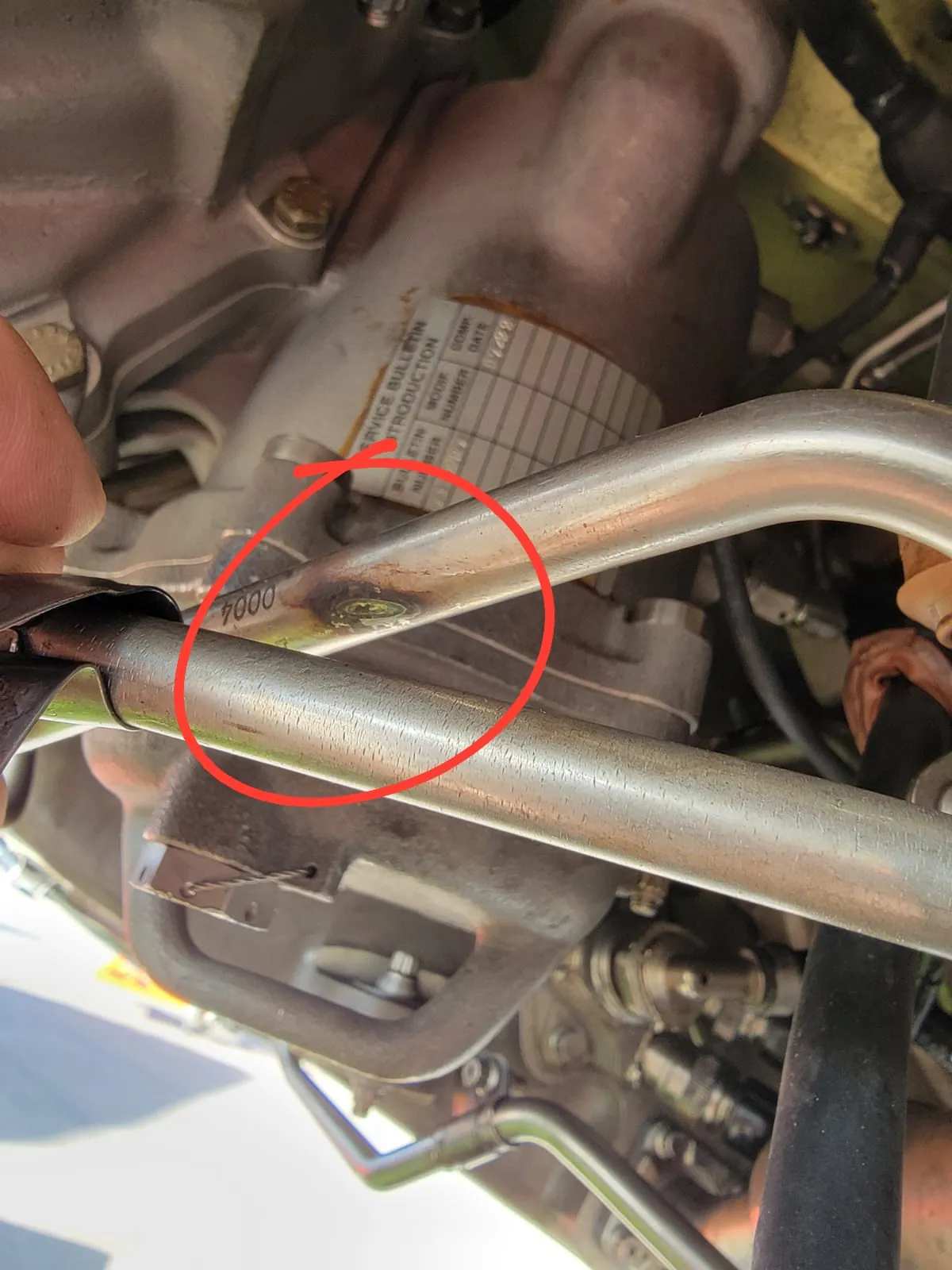 Chafed line circled on an engine accessory