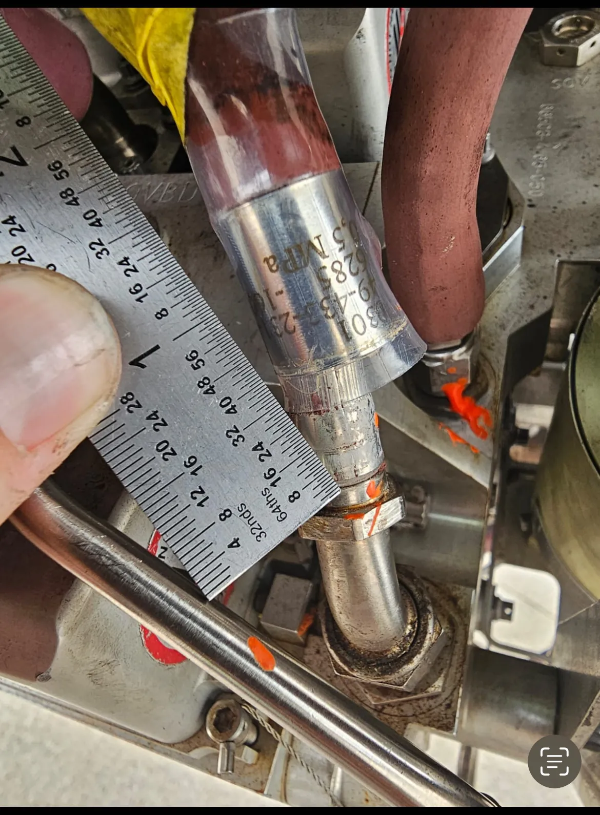 Measuring a fuel line fitting with a steel rule